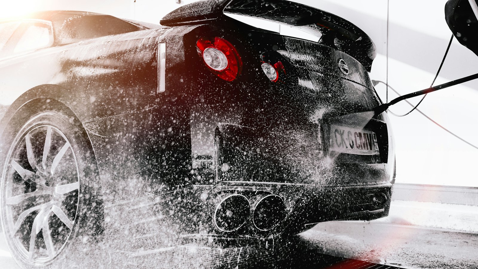 Sports car being rinsed with a pressure washer