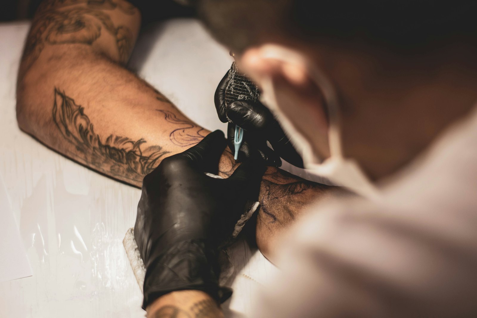 Artist tattooing a client's arm
