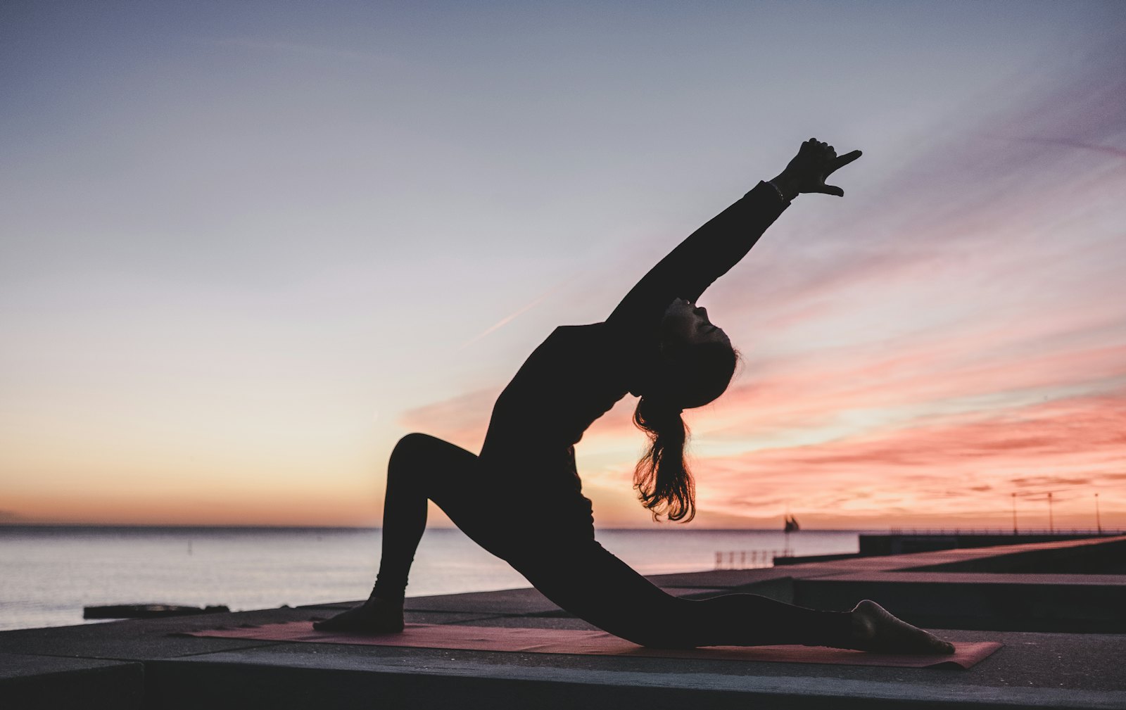 Person in a yoga pose at sunset