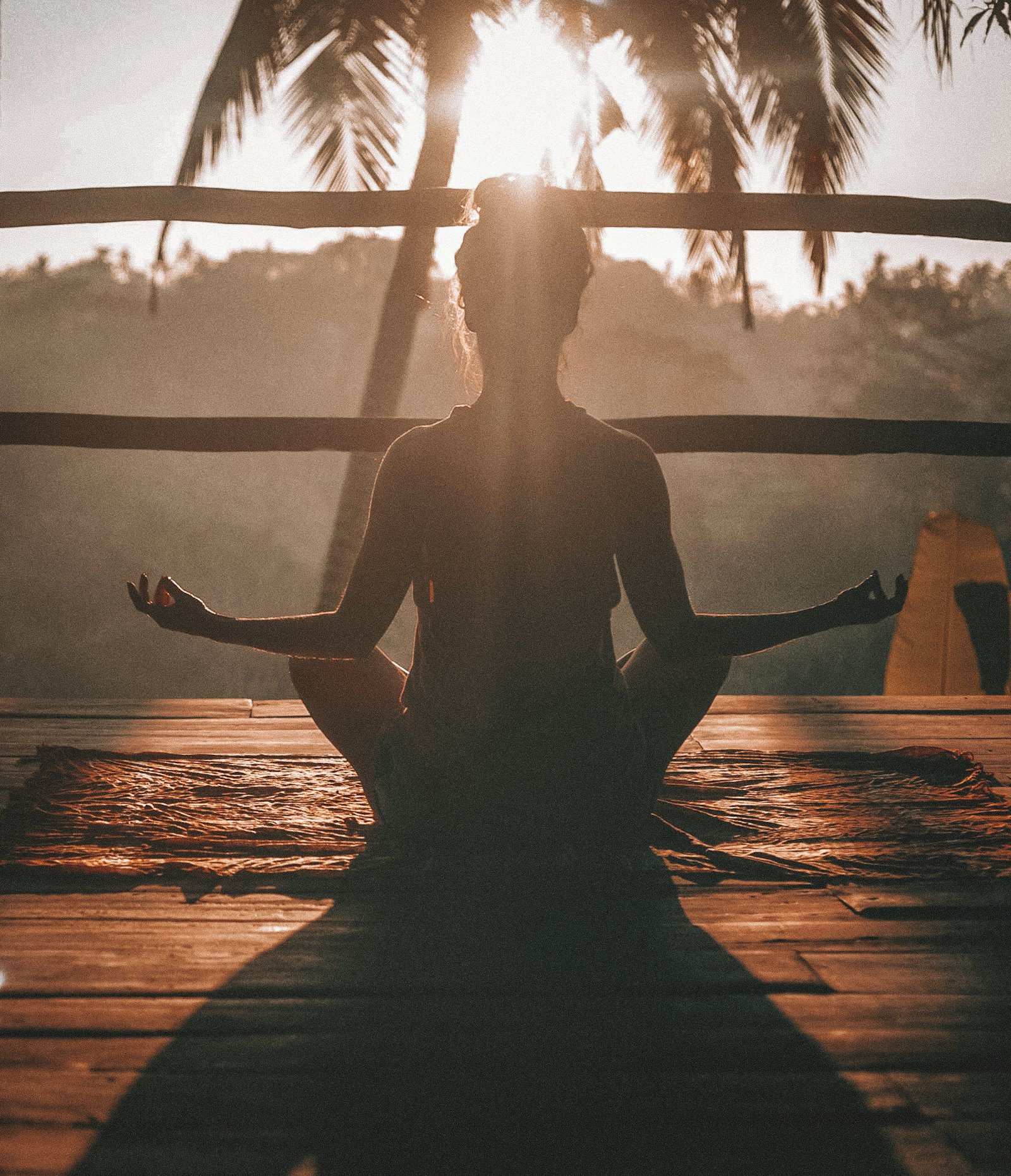 Silhouette meditating at sunset